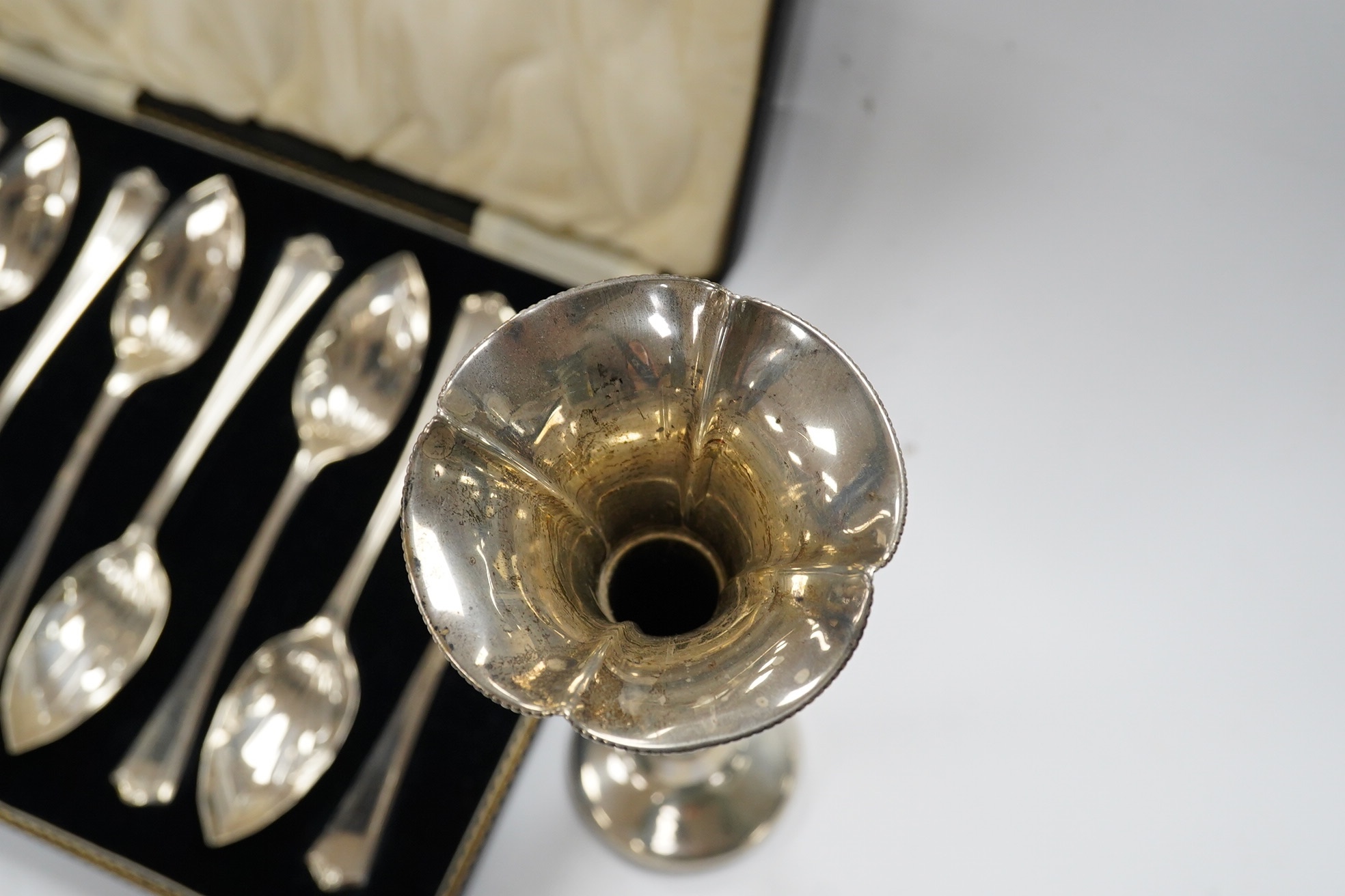 A cased set of eight George V silver grapefruit spoons, Sheffield, 1933 and a pair of silver spill vases, 17.5cm. Condition - poor to fair